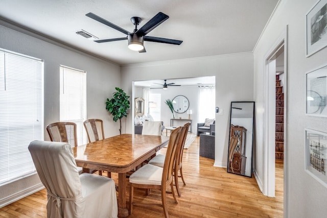 dining space with crown molding, light wood-type flooring, and ceiling fan