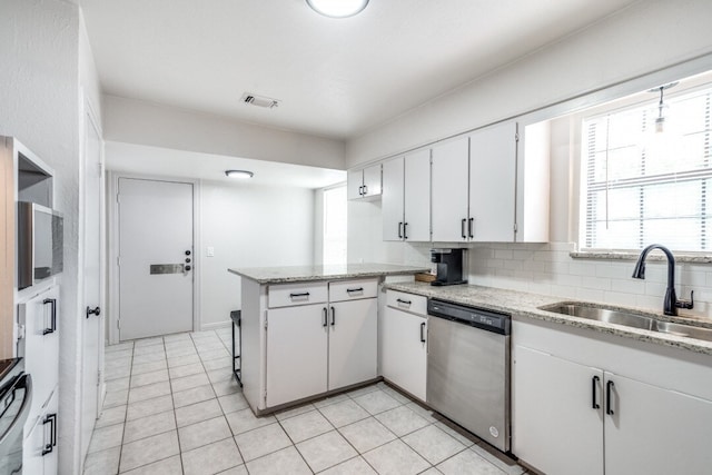 kitchen with sink, kitchen peninsula, backsplash, stainless steel dishwasher, and white cabinetry