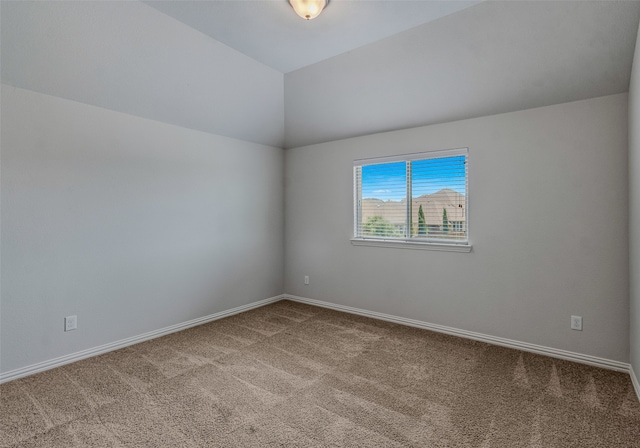 empty room with lofted ceiling and carpet