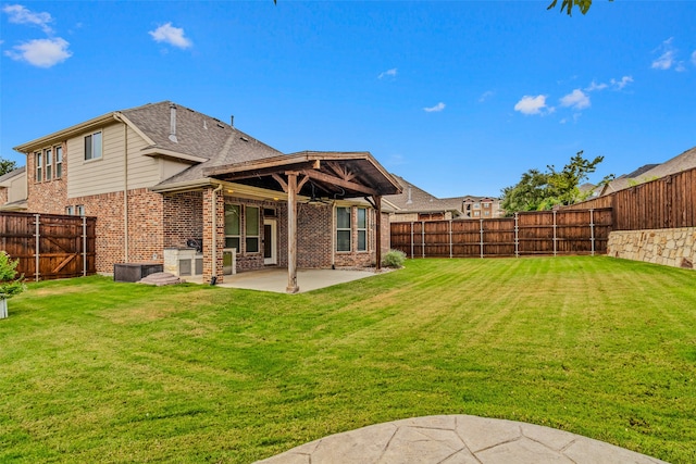 back of property with a lawn and a patio