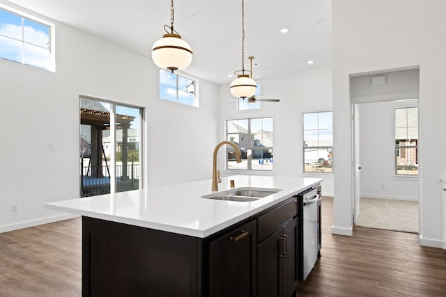 kitchen with pendant lighting, sink, dishwasher, a healthy amount of sunlight, and a center island with sink