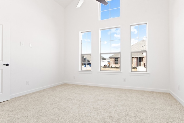 unfurnished room with high vaulted ceiling, ceiling fan, and carpet flooring