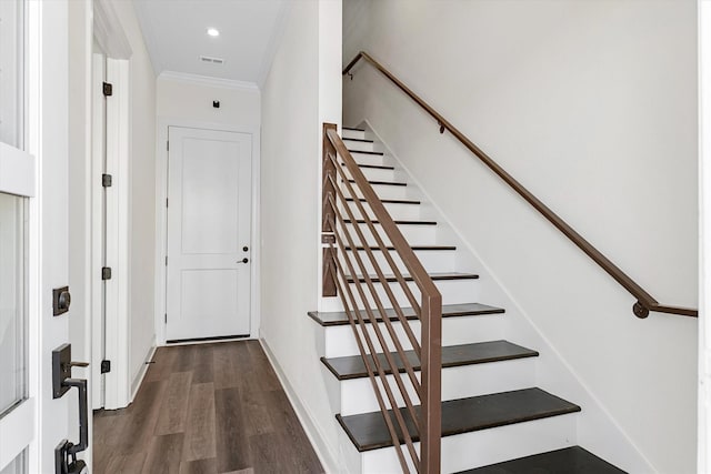 stairway with crown molding and dark hardwood / wood-style floors