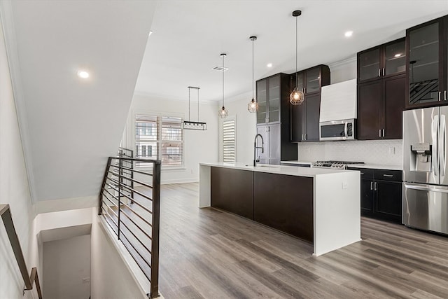 kitchen with ornamental molding, appliances with stainless steel finishes, and wood-type flooring