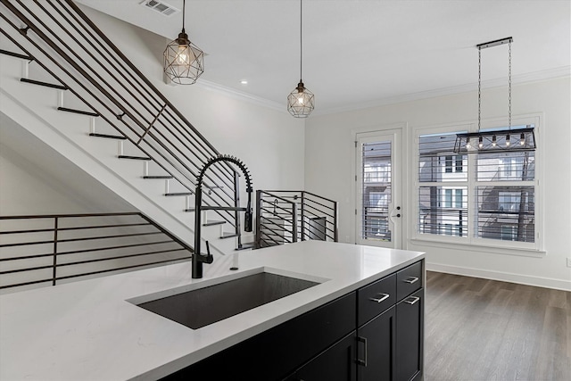 kitchen with crown molding, pendant lighting, dark hardwood / wood-style flooring, and sink