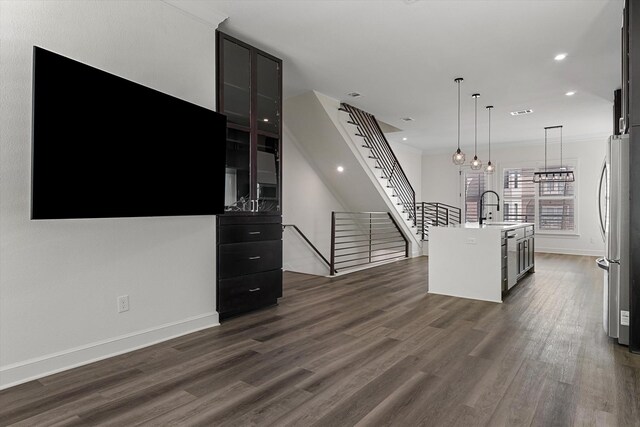 unfurnished living room featuring sink and dark hardwood / wood-style flooring