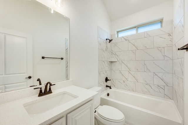 full bathroom featuring toilet, tiled shower / bath, vanity, and vaulted ceiling