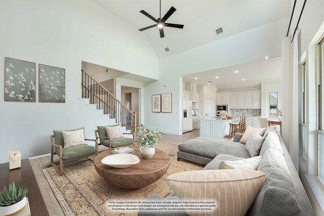 living room featuring ceiling fan, high vaulted ceiling, and light wood-type flooring