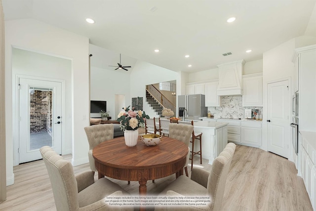 dining space featuring visible vents, stairs, light wood-type flooring, recessed lighting, and vaulted ceiling