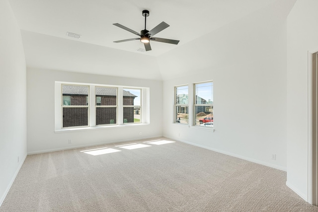 carpeted spare room featuring baseboards, ceiling fan, lofted ceiling, and visible vents