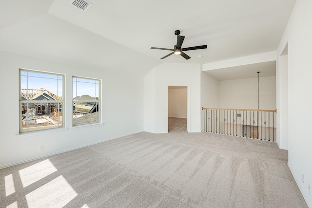 carpeted spare room with a ceiling fan, lofted ceiling, and visible vents