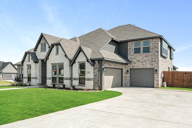 view of front facade with driveway, brick siding, fence, a front lawn, and a shingled roof
