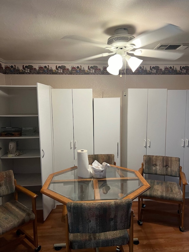 dining room with hardwood / wood-style flooring, a textured ceiling, and ceiling fan