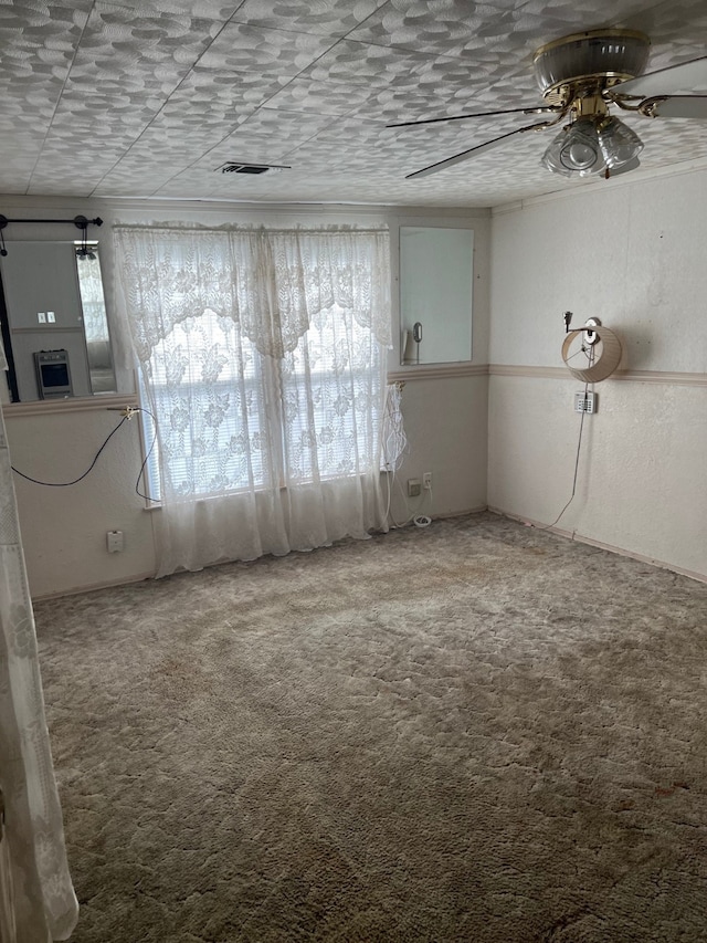 unfurnished room with carpet floors, ceiling fan, and a wealth of natural light