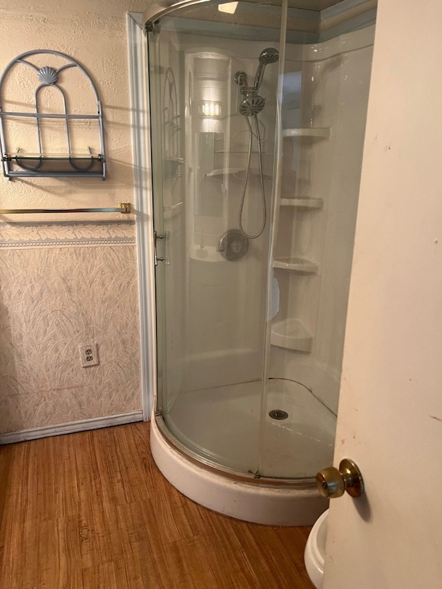 bathroom featuring a shower with shower door and hardwood / wood-style floors