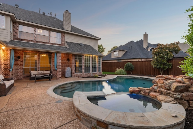 pool at dusk with a patio area