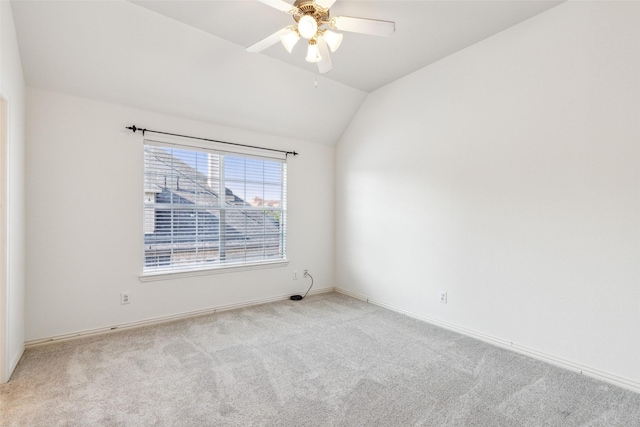 spare room featuring ceiling fan, vaulted ceiling, and light carpet