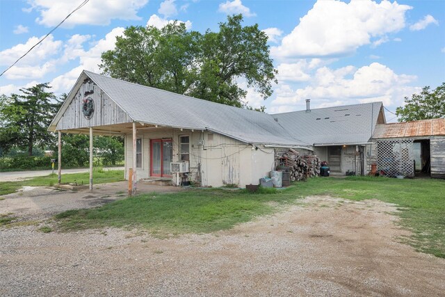 view of front of home featuring a carport, a front lawn, and cooling unit