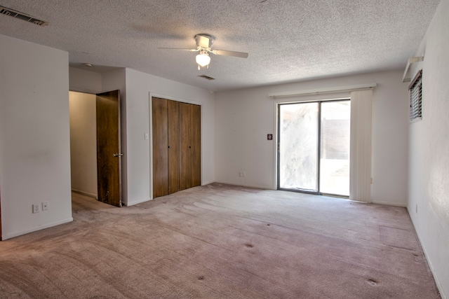 carpeted spare room with a textured ceiling and ceiling fan