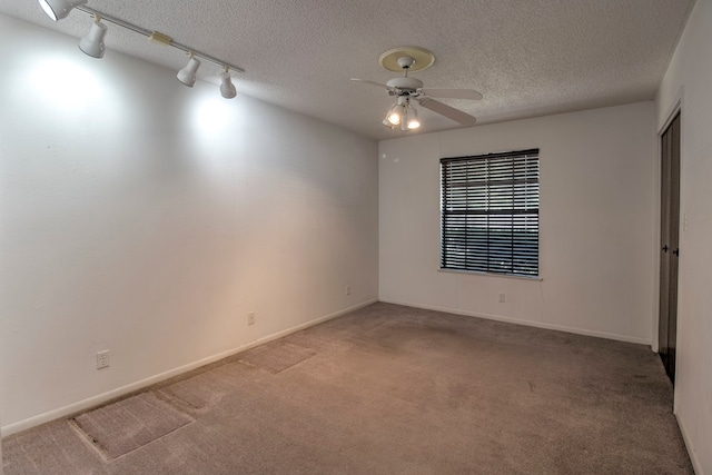 carpeted spare room with a textured ceiling, ceiling fan, and track lighting