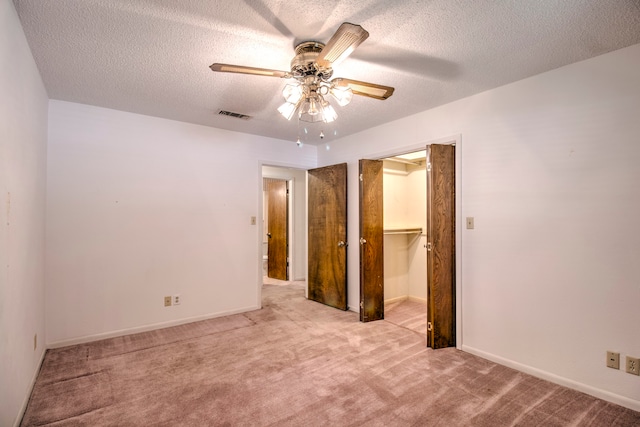 unfurnished bedroom featuring a closet, carpet flooring, a textured ceiling, and ceiling fan