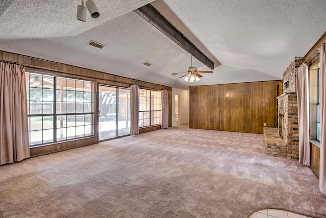 unfurnished living room featuring a textured ceiling, light carpet, a fireplace, and ceiling fan