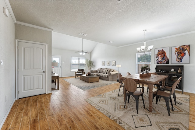 dining area featuring ceiling fan with notable chandelier, plenty of natural light, light hardwood / wood-style floors, and ornamental molding