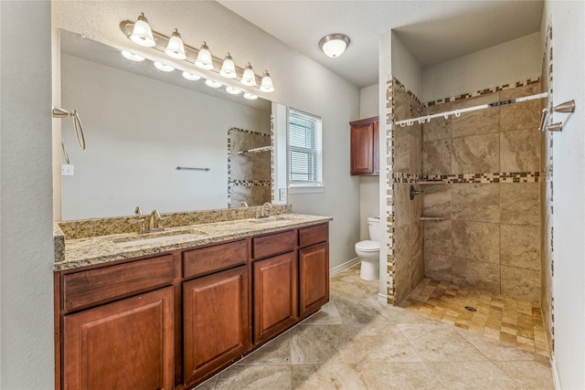 bathroom with tiled shower, toilet, and vanity