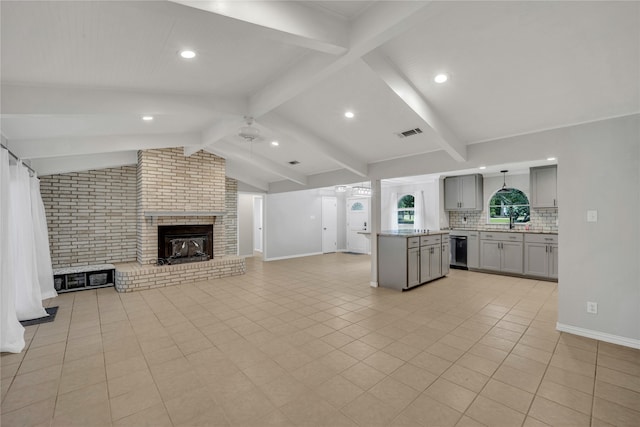 interior space featuring lofted ceiling with beams, brick wall, a fireplace, and light tile patterned floors