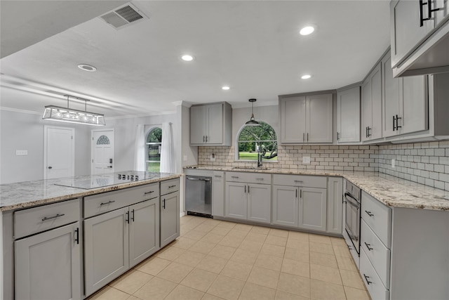 kitchen featuring crown molding, tasteful backsplash, light tile patterned floors, stainless steel appliances, and hanging light fixtures