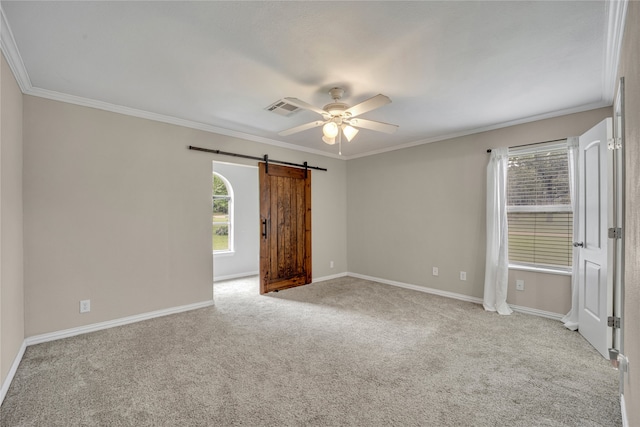 spare room with light carpet, a barn door, ceiling fan, and crown molding