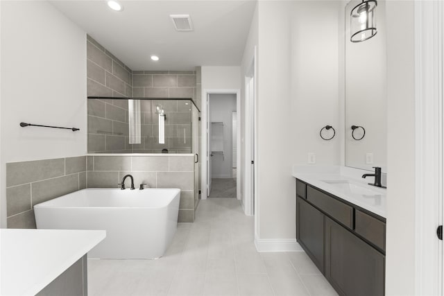 bathroom featuring separate shower and tub, vanity, and tile patterned floors