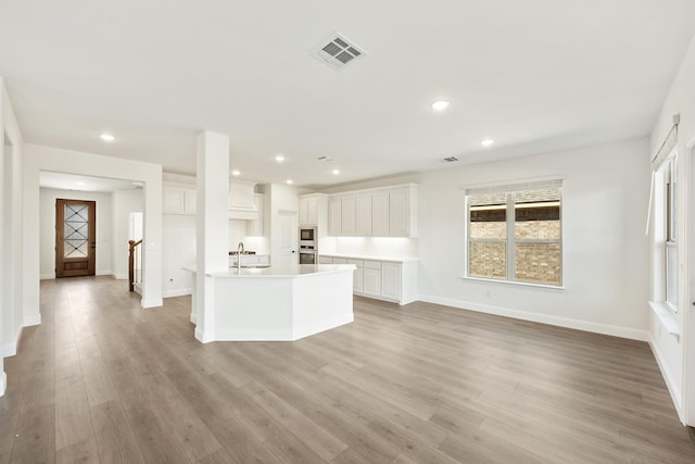 unfurnished living room featuring light hardwood / wood-style floors and sink