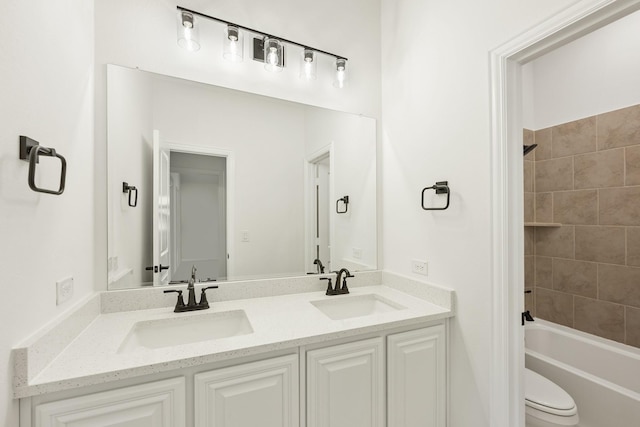 full bathroom with tiled shower / bath, vanity, and toilet