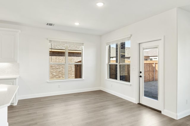 unfurnished dining area with a healthy amount of sunlight and light hardwood / wood-style floors