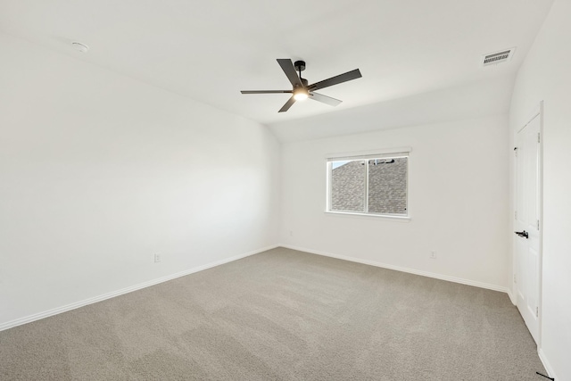 carpeted spare room with ceiling fan and vaulted ceiling