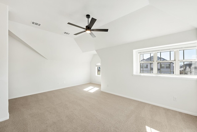 additional living space with ceiling fan, lofted ceiling, and light carpet