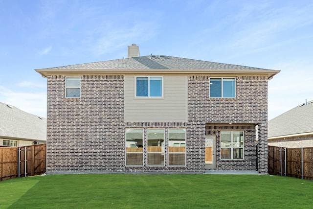 rear view of house featuring a lawn