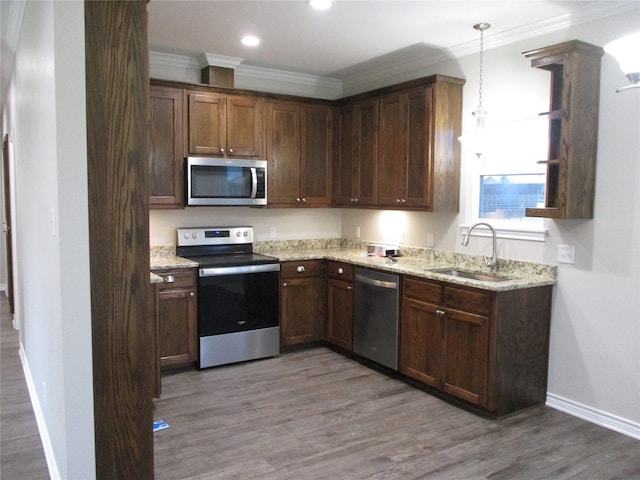 kitchen featuring appliances with stainless steel finishes, decorative light fixtures, dark hardwood / wood-style flooring, and sink