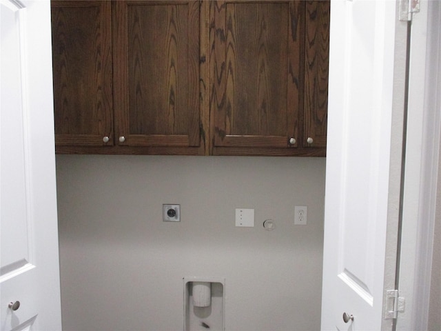 clothes washing area featuring cabinets, gas dryer hookup, and electric dryer hookup