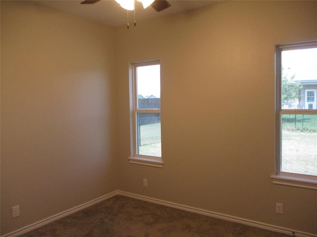 carpeted empty room featuring ceiling fan and a wealth of natural light