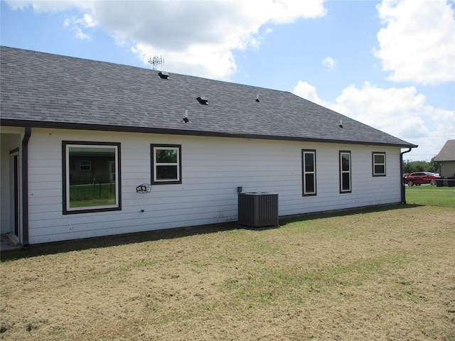 rear view of house featuring a yard and central AC unit