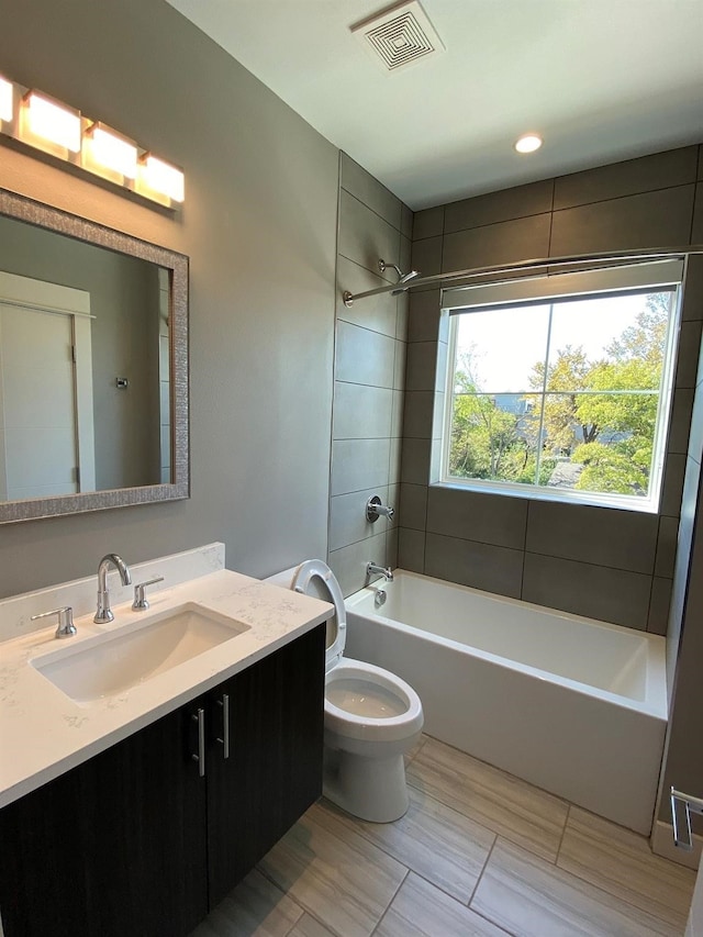 full bathroom with vanity, toilet, tiled shower / bath, and tile patterned flooring