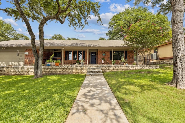 ranch-style home featuring a porch, a front yard, and a garage