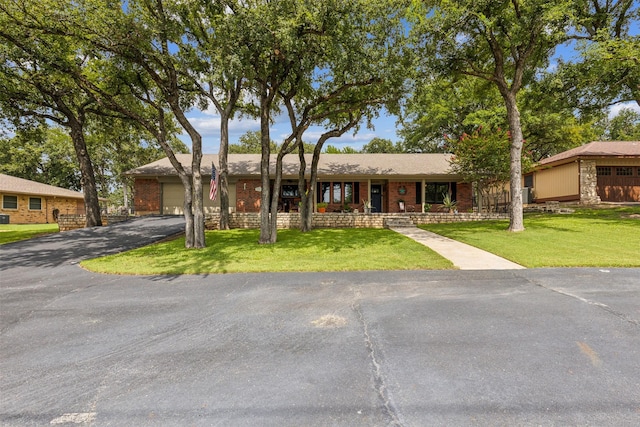 single story home featuring a front yard and a garage