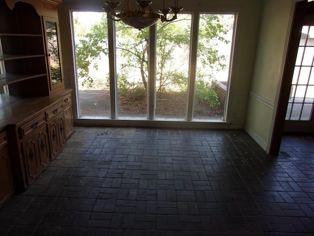 unfurnished dining area with an inviting chandelier and a wealth of natural light