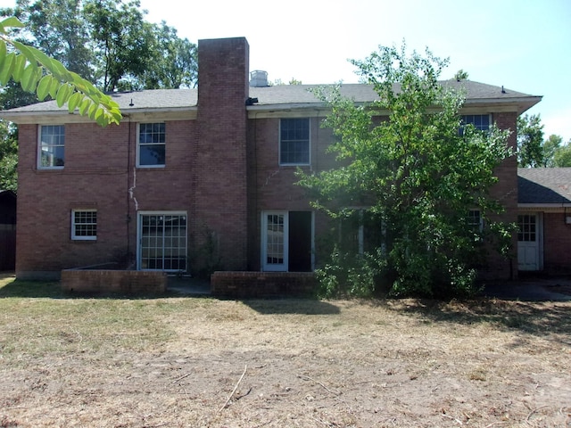 back of property featuring a lawn