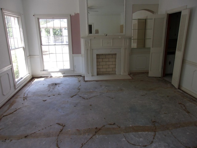 unfurnished living room with a wealth of natural light and ceiling fan