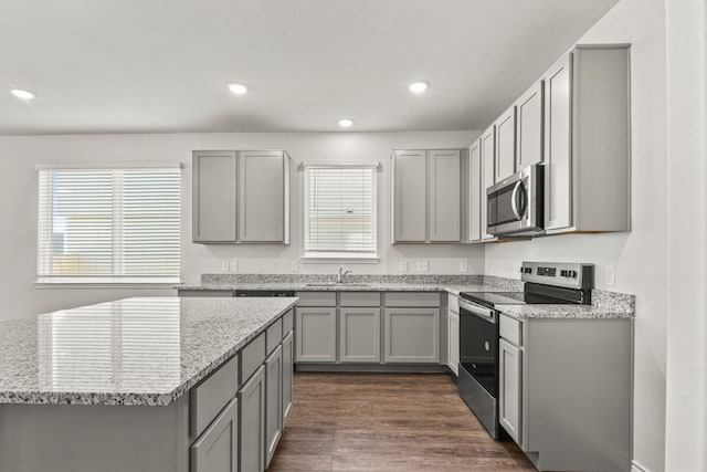 kitchen featuring sink, light stone counters, appliances with stainless steel finishes, and gray cabinets