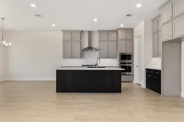 1417 Vermillion Dr, Prosper, TX 75078 - kitchen with gray cabinets, stainless steel appliances, backsplash, visible vents, and wall chimney range hood